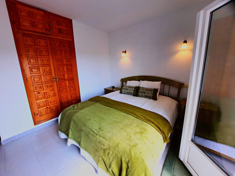 Bedroom with green bedspread and traditional wooden door