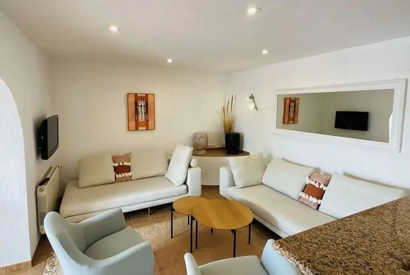 Lounge with two white sofas and TV